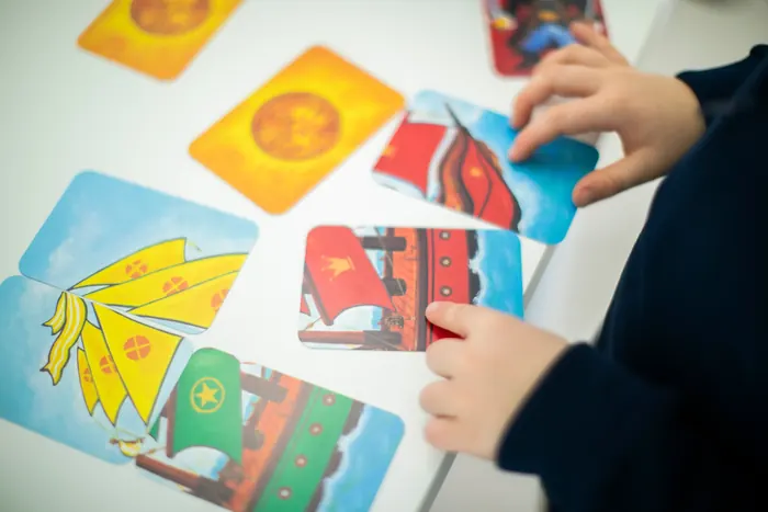 Le mani di un bambino e di un adulto che giocano con le carte illustrate